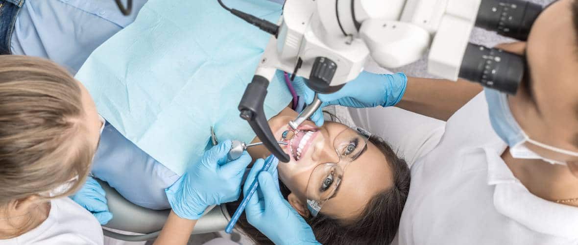 Pacjentka w gabinecie stomatologicznym podczas zabiegu stomatologicznego z użyciem mikroskopu.